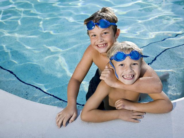 Child-learning-to-swim-with-instructor-in-pool)